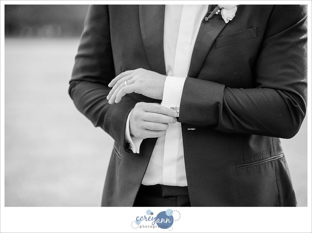 Groom adjusting cufflinks after wedding ceremony in Northeast Ohio