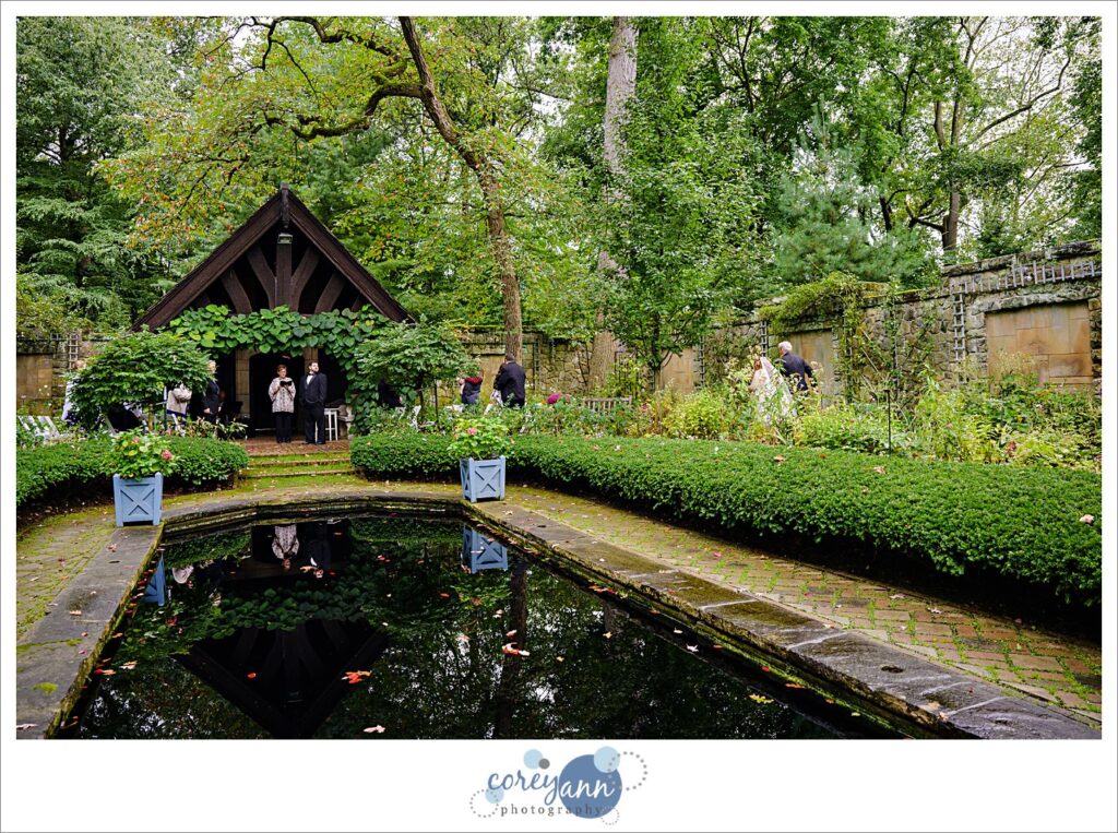 Bride and her father walking towards her groom during wedding ceremony in the English Garden at Stan Hywet in Akron