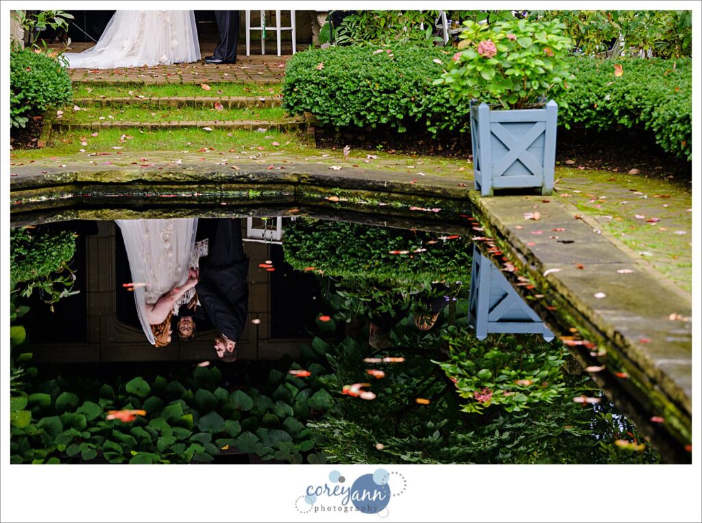 Wedding ceremony reflected in the water in the English Gardens at Stan Hywet in Akron Ohio