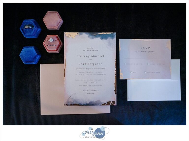 Flatlay with wedding stationery and rings that have a modern blue and pink style