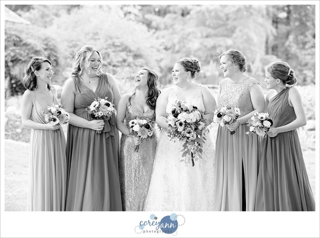 Bride with bridesmaids in varied pink gowns at Tudor House on Portage Lakes in Akron Ohio