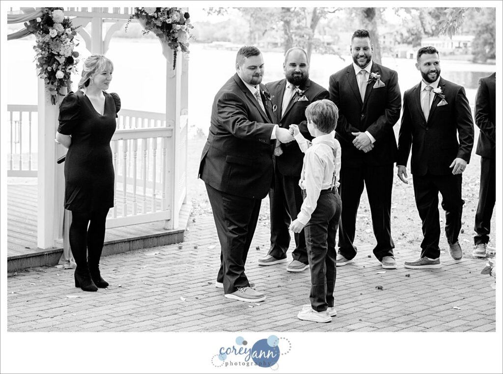 Ring bearer fist bumping the groom at Tudor House on Portage Lakes in Akron Ohio