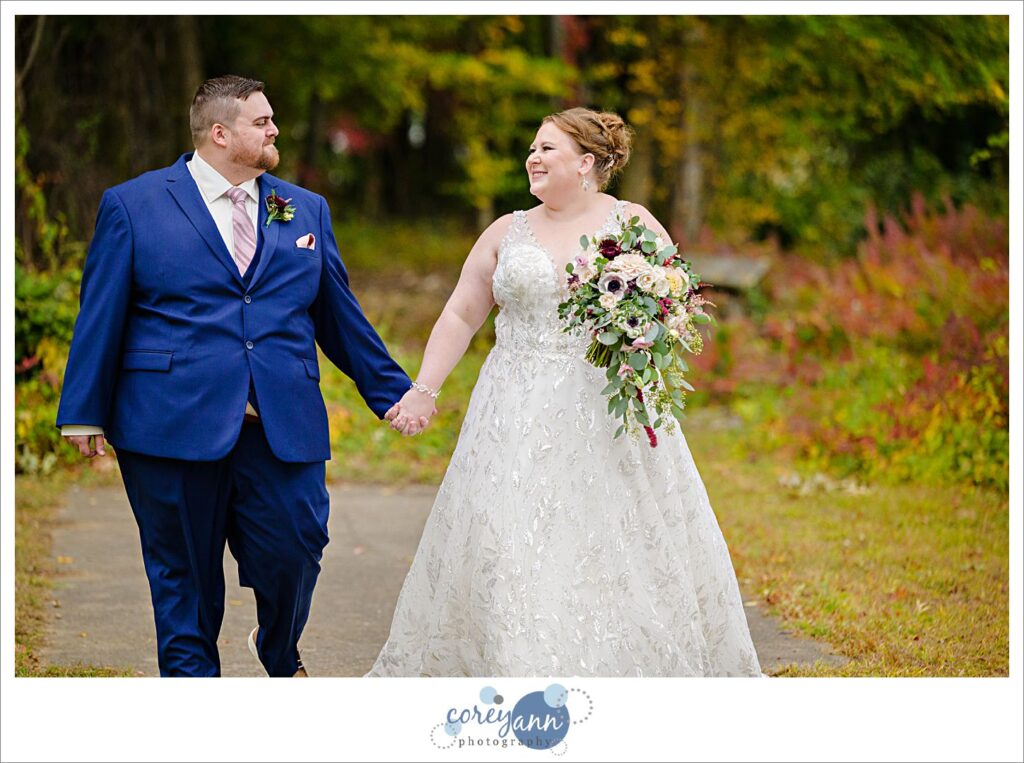 Bride and Groom walking near wooded path near Turkeyfoot Lake in September in Akron Ohio