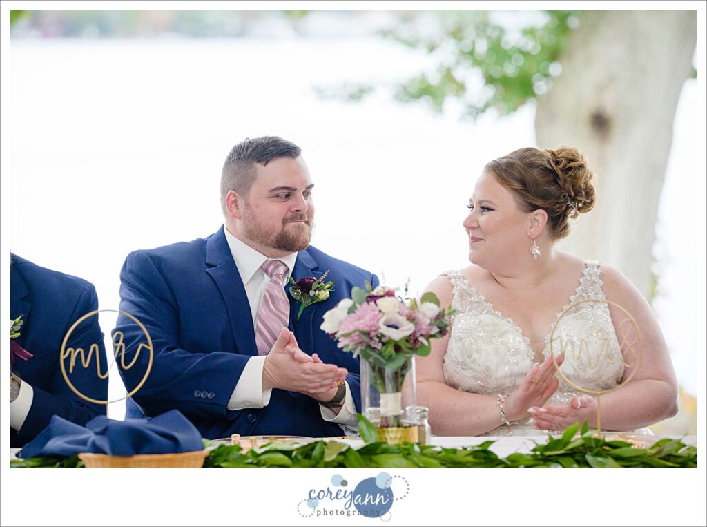 Bride and groom reacting to emotional toast given during wedding reception at Tudor House on Portage Lakes
