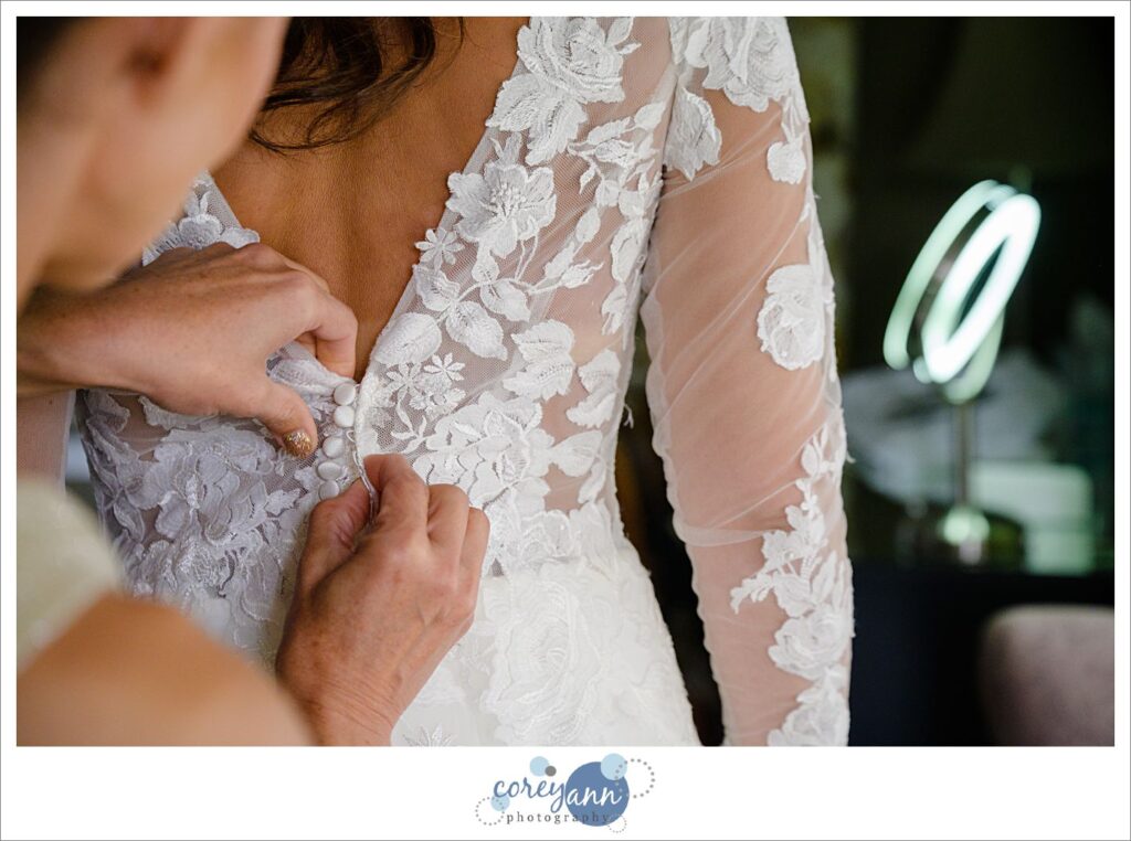 Bride's mother buttoning her dress as they get ready for a wedding in Cleveland Ohio in October