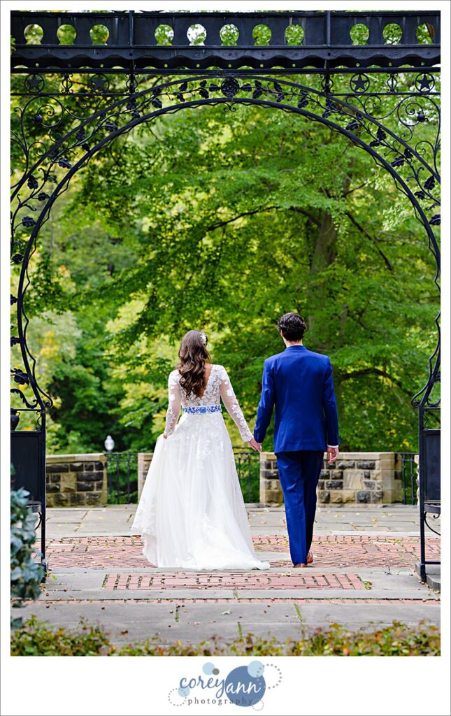 Bride and Groom walking beneath the iron arch in the Hungarian Cultural Gardens in Ohio