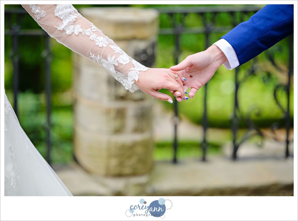 Close up of bride and groom's hands as they walk during portraits before their wedding in Ohio