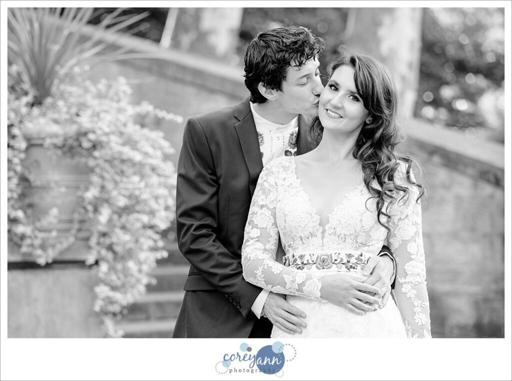 Black and white wedding portrait of a groom kissing his bride to be on the cheek before their wedding in Cleveland Ohio