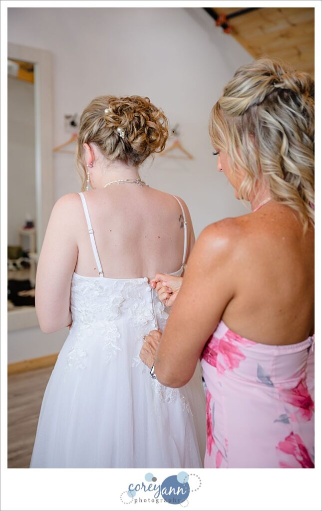 Bride's Mom helping her get dressed for wedding in Canal Fulton Ohio