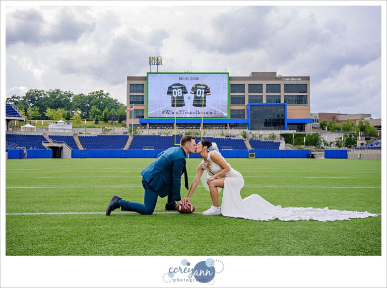 Bride and Groom kissing on the field at the Pro Football Hall of Fame after their wedding