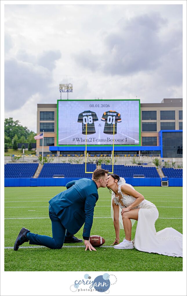 bride and groom posing after wedding on football field at tom benson hall of fame stadium in canton ohio