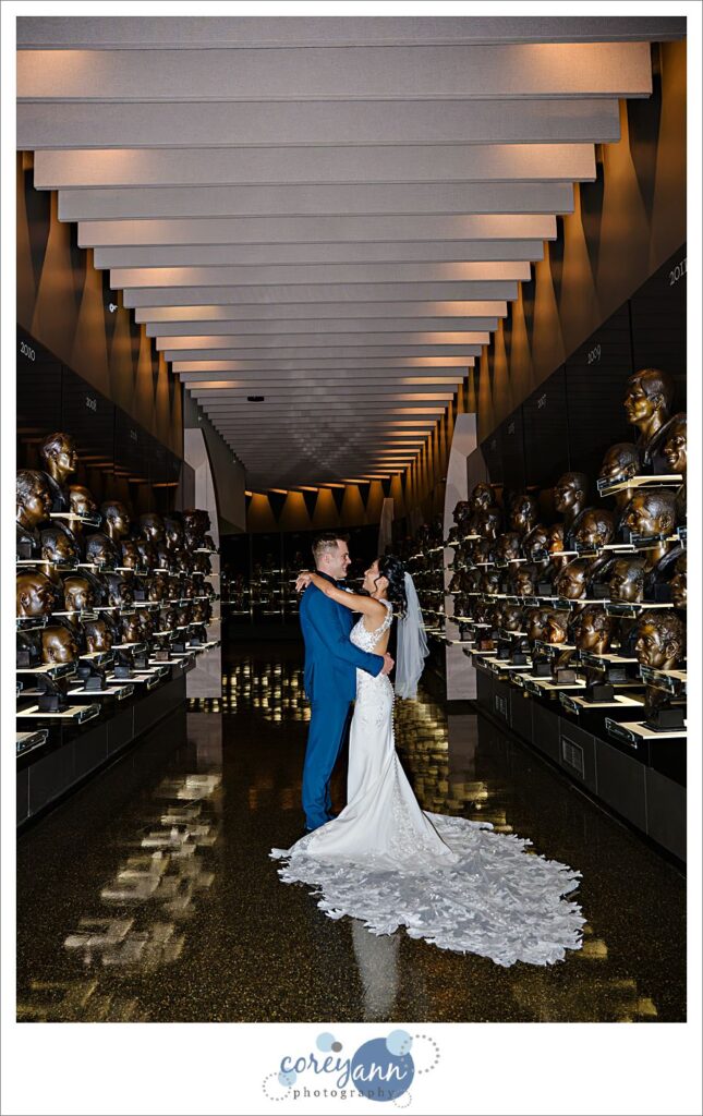 bride and groom posing with trophies at professional football hall of fame museum in canton ohio wedding