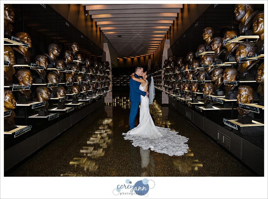 bride and groom posing with trophies at professional football hall of fame museum in canton ohio wedding
